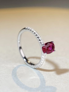 Macro side view of S925 sterling silver ring with oval ruby and pavé set side stones