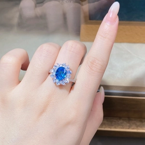 Macro shot of a floral S925 silver ring with an oval blue sapphire and marquise zircons