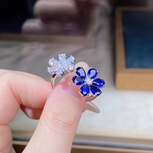 Macro shot of 925 silver double flower ring with blue sapphire and clear cubic zirconia