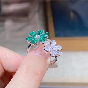 Close-up of S925 silver ring featuring emerald green and white zircon flowers on finger