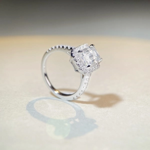 Détail macro d'une bague moissanite 2 carats taille émeraude avec halo et anneau pavé