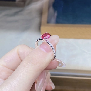 Macro shot of S925 silver ring featuring an oval pigeon blood red ruby and side diamonds