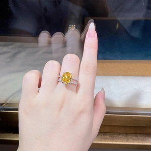 Macro shot of cushion cut yellow diamond ring with split shank pavé diamonds