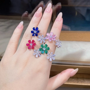 Detailed view of multiple colorful S925 silver flower rings with pear-cut gemstones