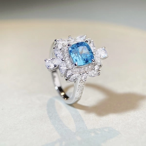 Bague cocktail en argent S925 avec zircon bleu taille coussin et design floral halo