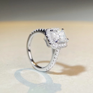Vue macro de côté d'une bague moissanite 2 carats taille radiant avec halo et diamants