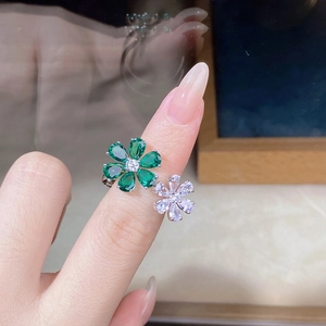 Close-up of S925 silver double flower ring with emerald green and white zircons on hand