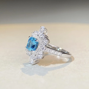 Vue macro d'une bague en argent S925 avec pierre carrée bleue et entourage de zircons
