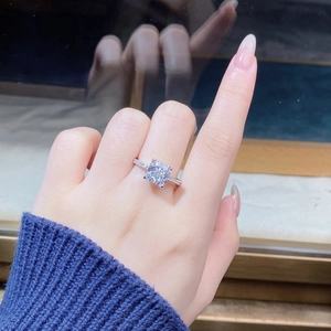 Macro detail of square cut white zircon ring with four-prong setting and pavé band