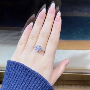 Close-up of a square cut princess diamond ring on finger with side stone accents