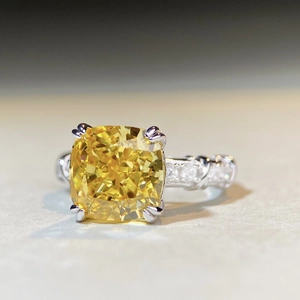 Dettaglio anello con zircone giallo taglio cushion e fascia d'argento a treccia