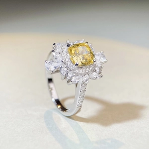 Macro shot of cushion cut yellow diamond ring with floral white gem halo set in silver