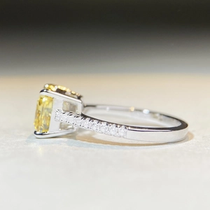 Macro shot of silver ring with radiant emerald-cut yellow stone and pavé-set side diamonds