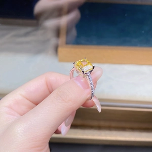 Macro detail of square yellow zircon ring with micro-pave white diamonds on silver band