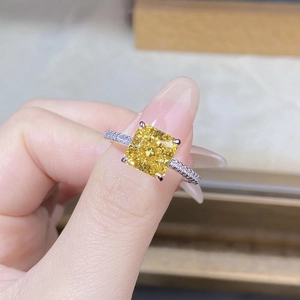 Macro view of a square yellow gemstone set in a gold-plated silver ring with side diamonds
