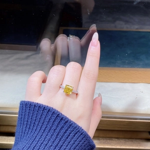 Macro shot of S925 silver ring featuring a radiant cut yellow zircon on woman index finger
