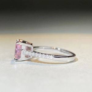 Detailed side view of rectangular pink gemstone ring with silver band and pavé setting