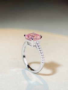 Macro detail of rectangle pink gemstone with four-prong silver setting and side diamonds