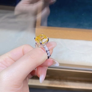 Vista macro dell'anello con zircone giallo taglio cushion, griffe in argento e pavé