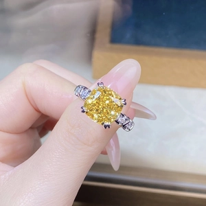Dettaglio anello con pietra gialla taglio cushion e fascia in argento con diamanti