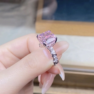 Close-up of a pink rectangle gemstone ring with four-prong setting and paved diamond band