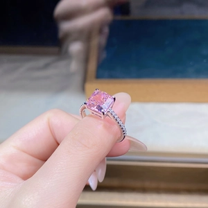 Macro detail of a pink princess cut stone ring with a classic four-prong silver setting