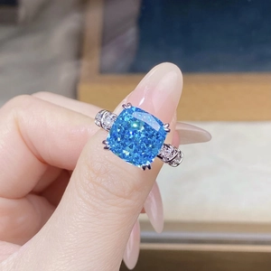 Macro shot of cushion-cut blue gemstone ring with pave diamond silver band