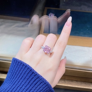 Detail of pink cushion-cut gemstone ring on hand with silver criss-cross band