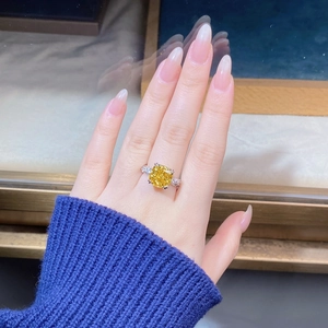 Vista dettagliata dell'anello di lusso con pietra gialla taglio cushion e pavé di diamanti