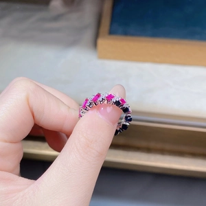 Close-up of silver ring featuring alternating rectangular red and black gemstones