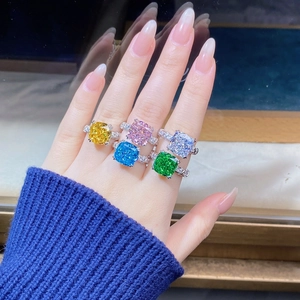 Close-up of five colorful square-cut gemstone rings stacked on hand for a stylish jewelry look