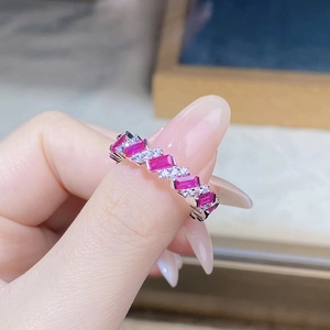 Detail showing alternating pink rectangular gems and round diamonds on a silver band