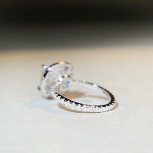 Macro side view of sterling silver moissanite ring with pave setting and radiant cut stone
