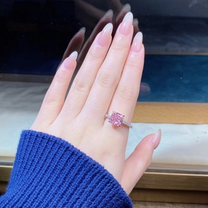 Close-up of a silver ring featuring a large square pink gemstone and side diamonds