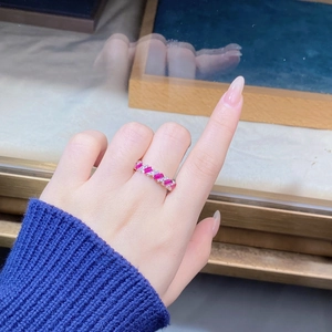 Close-up of eternity ring with alternating rectangular pink stones and round diamonds