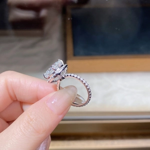 Macro shot of a 5-carat oval cut moissanite ring with halo setting and pavé diamonds