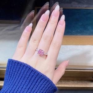 Close-up of square cut pink gemstone ring with micro-pave diamonds on silver band