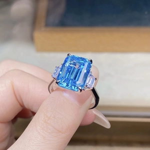 Macro shot of an emerald-cut blue aquamarine gemstone ring with side trapezoid diamonds