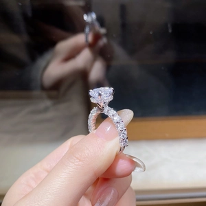 Macro shot of 4-prong moissanite ring with pave diamond band on sterling silver