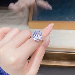Macro shot of an emerald cut centerpiece with baguette side stones on a silver ring