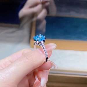 Detailed macro view of silver ring featuring a square blue stone and pavé set diamonds