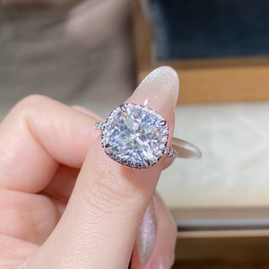Macro shot of cushion cut moissanite ring with halo setting and pavé diamonds