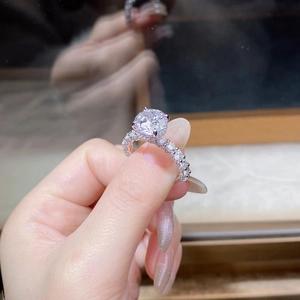 Macro view of sterling silver moissanite ring with round cut center stone and pavé accents