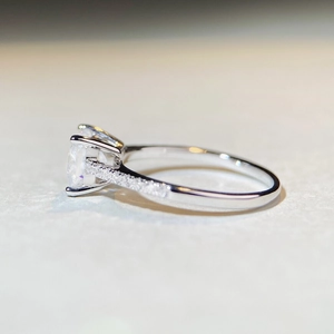 Side view detail of square moissanite ring with four-claw setting on silver band