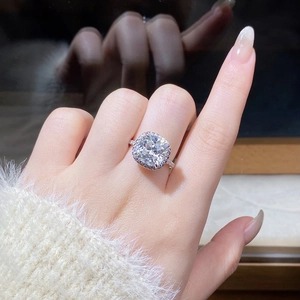 Close-up of a 5-carat cushion-cut moissanite ring with halo setting on silver band