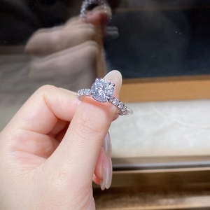 Macro shot of 3ct round cut moissanite ring with six-prong setting on woman's finger