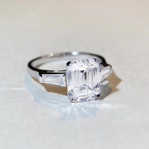 Macro view of emerald cut gemstone ring with baguette side stones in S925 silver