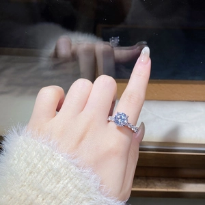 Close-up of a 3-carat moissanite ring with six-prong setting and side accent diamonds