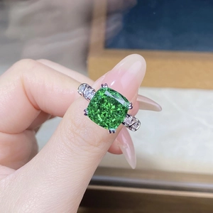 Macro view of emerald-cut green stone with white zircon accents on silver ring