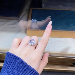 Detailed view of an emerald cut cubic zirconia cocktail ring on a hand in silver finish